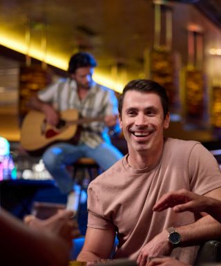 guy laughing with guitar player in abckground