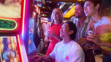 Guests gathered around a slot machine watching someone play on a slot