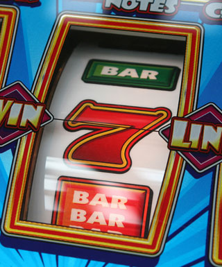 A view of one reel on a classic slot machine showing the "bar" symbol and a 7.